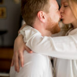 дівчина обіймає хлопця і цілує в ніс