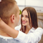 дівчина тримає хлопця за голову і дивиться йому в очі